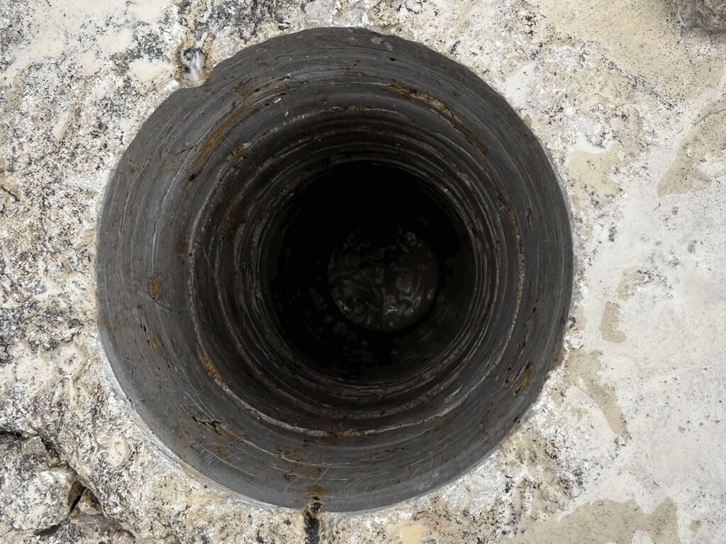 Paekivisse puuritud ümar 132 mm auk ülevalt vaadatuna, seintel teemantkrooni ringjäljed
